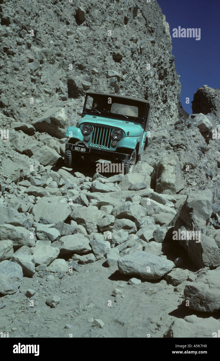 Jeep negotiating landslide near Chalt Northwest Pakistan Asia Use low range first gear four wheel drive to crawl over boulders Stock Photo