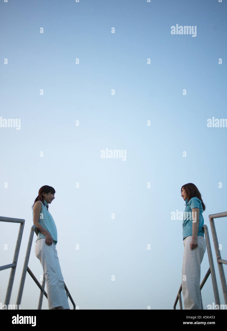 Two young women standing facing each other Stock Photo