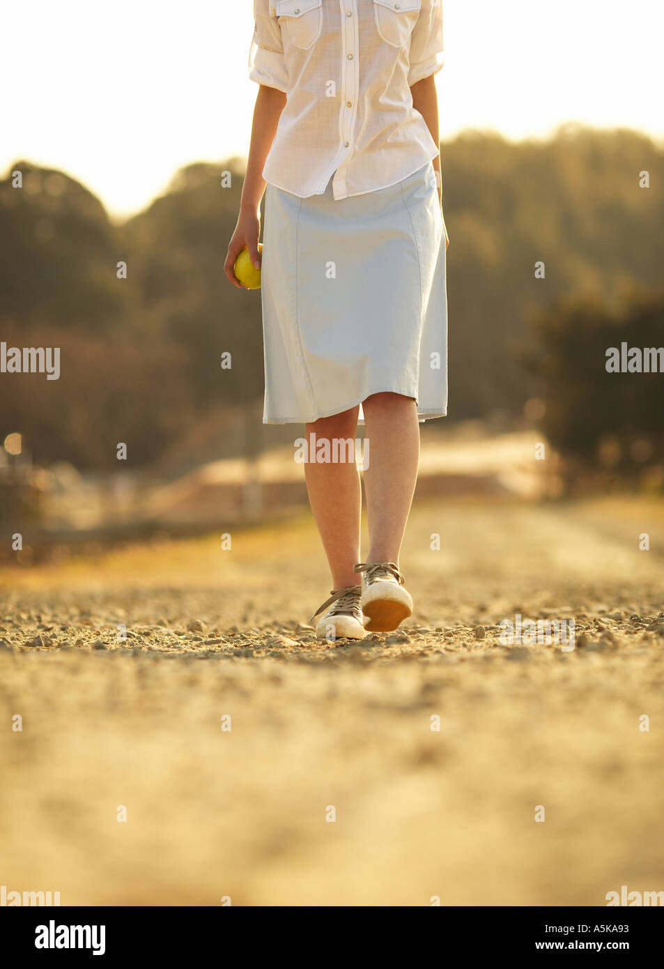 Woman walking holding skirt hi-res stock photography and images - Alamy