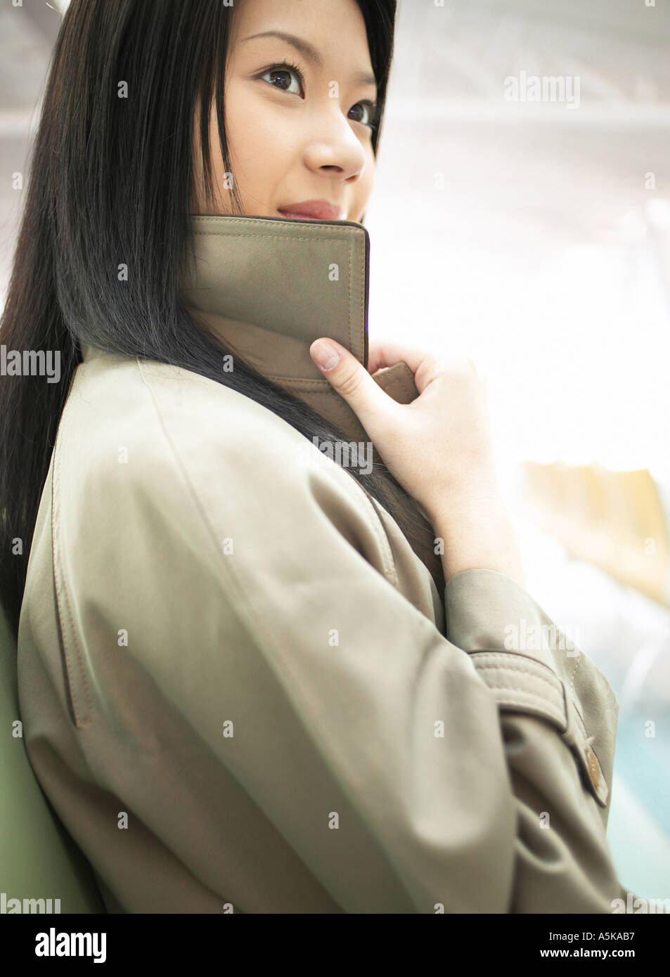 Young woman wearing a trench coat Stock Photo - Alamy