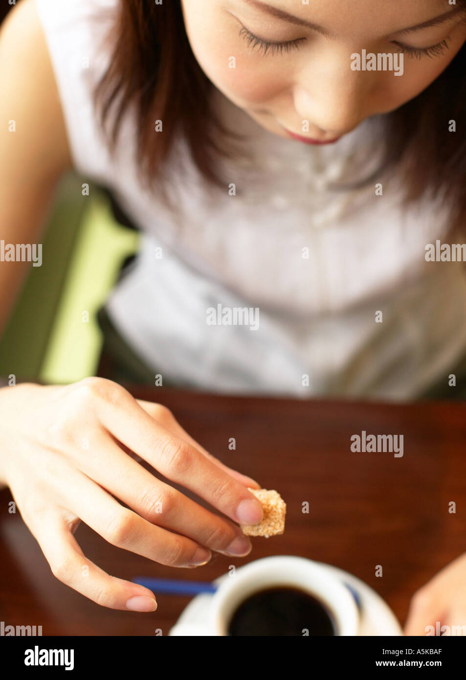 Young woman adding sugar in tea Stock Photo