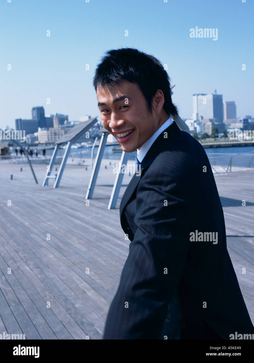 Asian Man walking on a bridge Stock Photo - Alamy