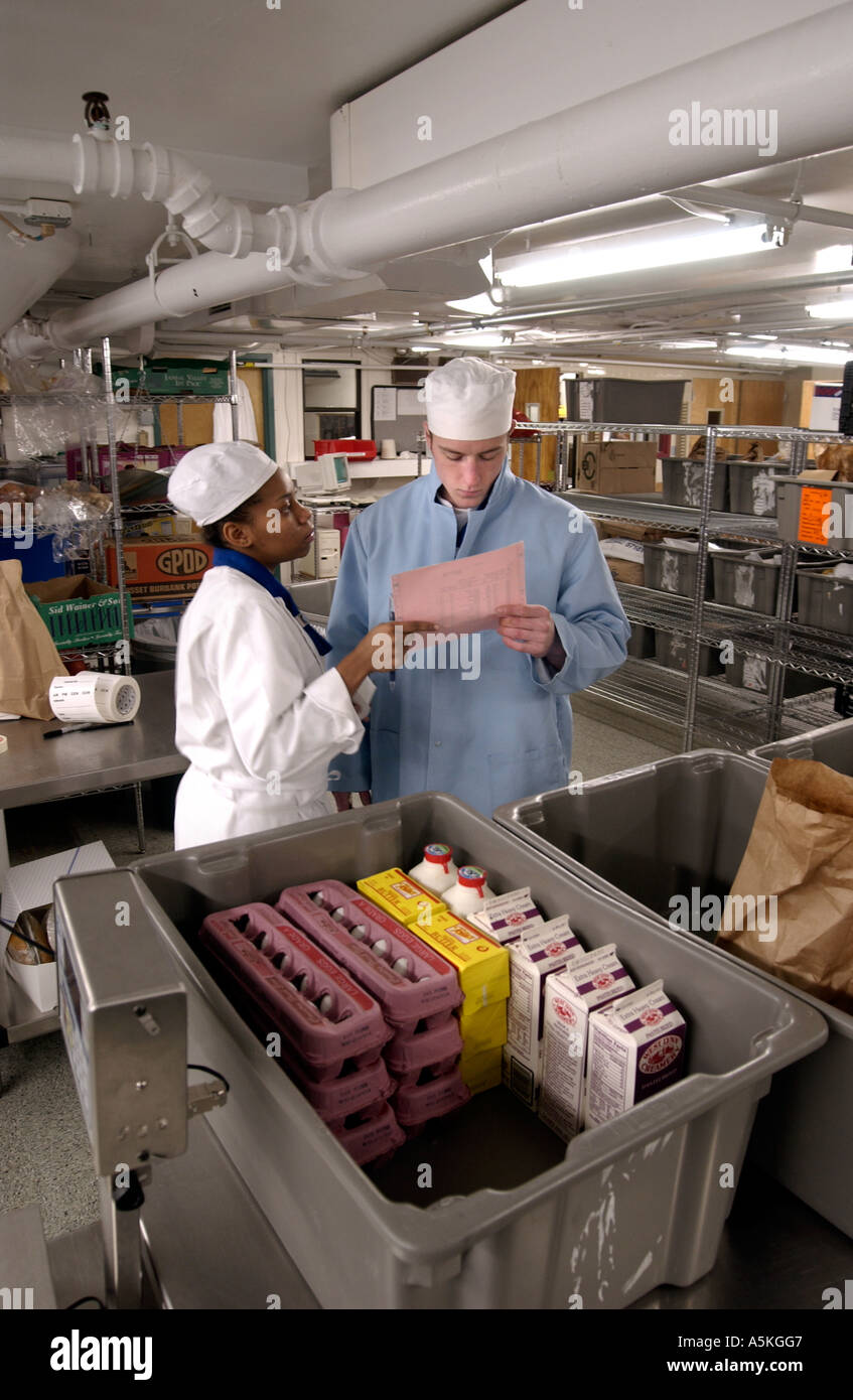 Chef and cook look over inventory in massive kitchen at restaurant Stock Photo