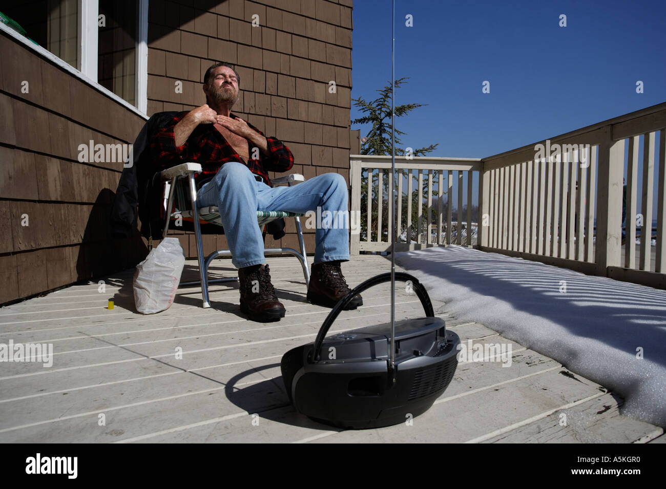 A man suntans in the dead of winter on an unusually warm day in Connecticut Stock Photo
