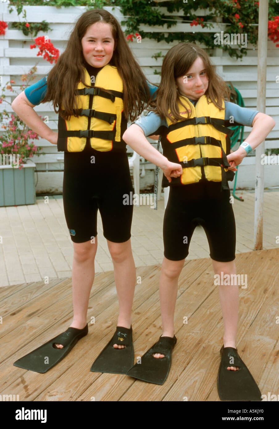 Two girls wearing wetsuits strike a silly pose while visiting Theatre
