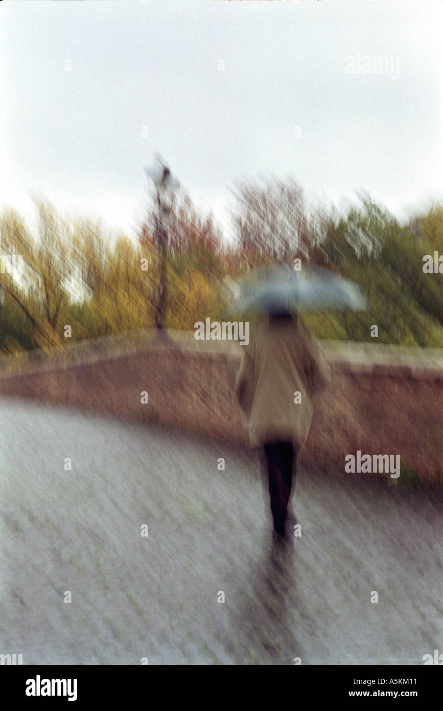 old man walking with umbrella blur Stock Photo - Alamy
