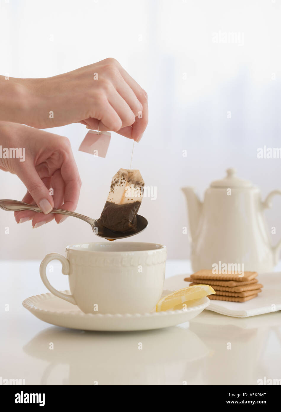 Woman taking tea bag out of cup Stock Photo