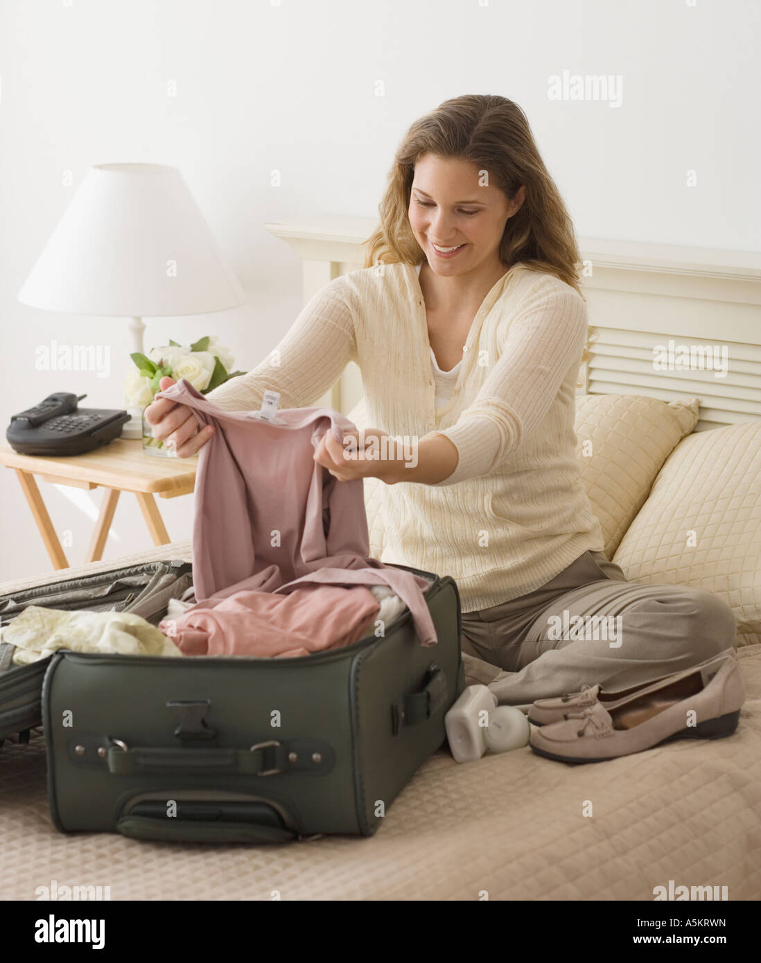 Woman unpacking in hotel room Stock Photo