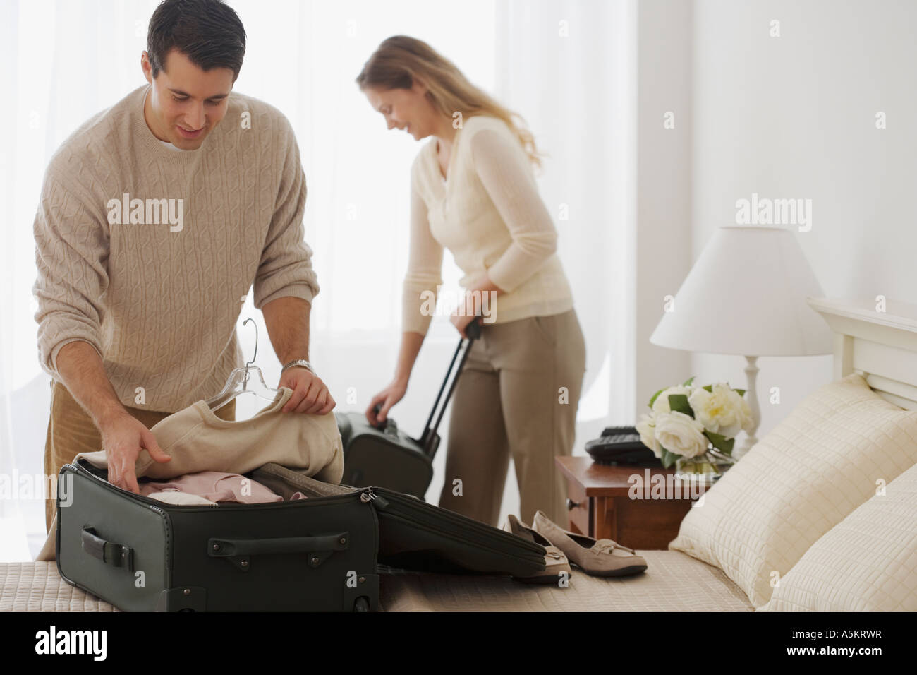Couple unpacking in hotel room Stock Photo
