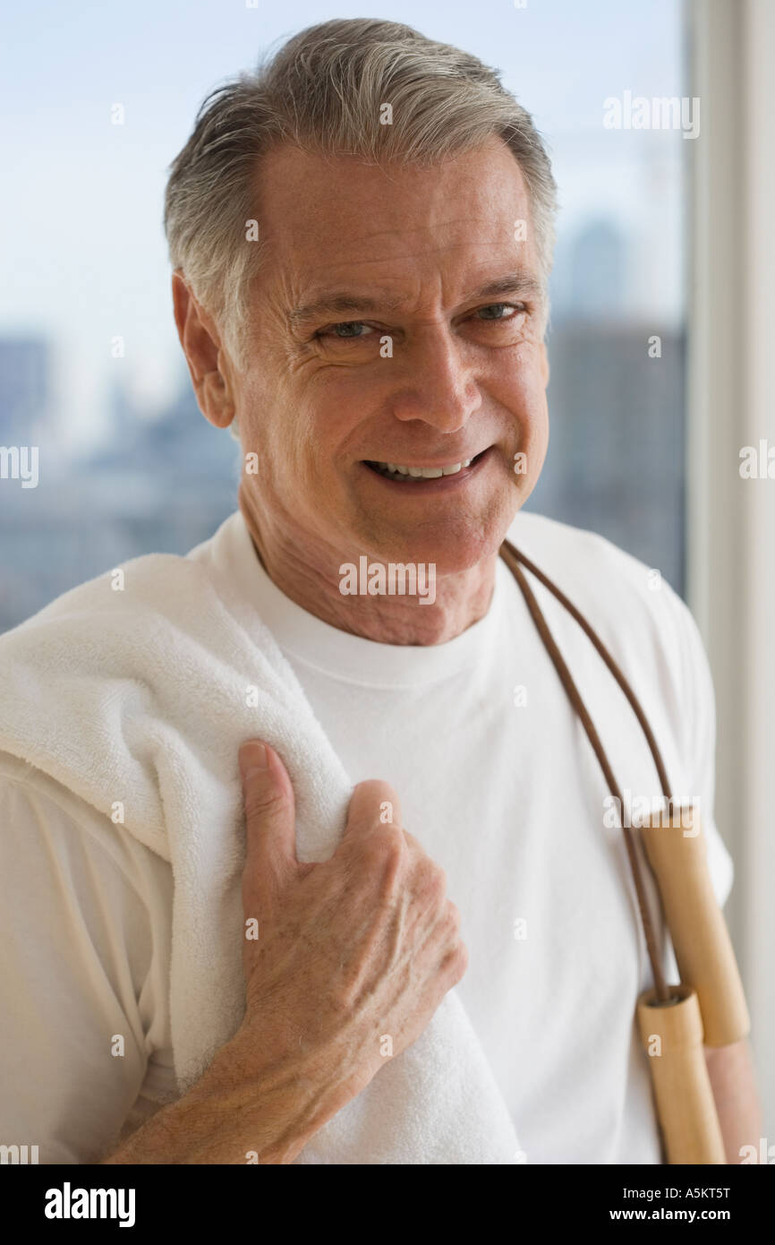 Portrait of senior man holding jump rope over shoulder Stock Photo