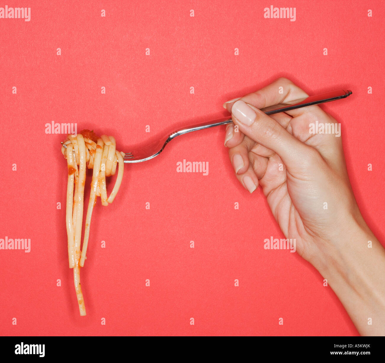 Woman holding forkful of pasta Stock Photo