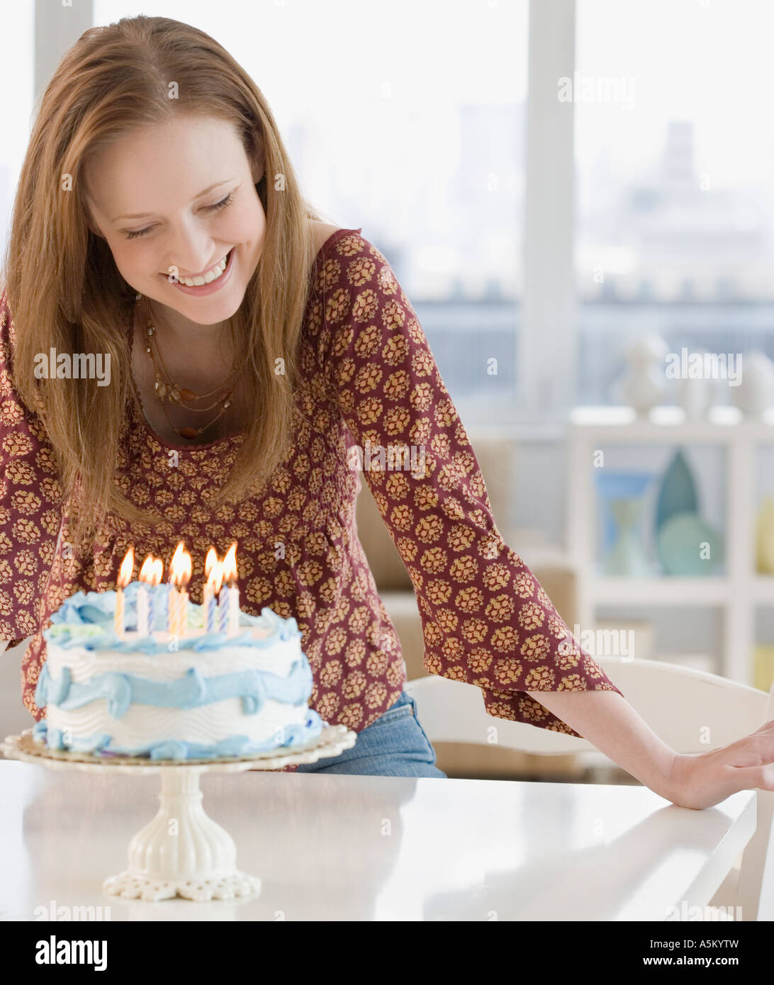 Woman smiling at birthday cake Stock Photo - Alamy
