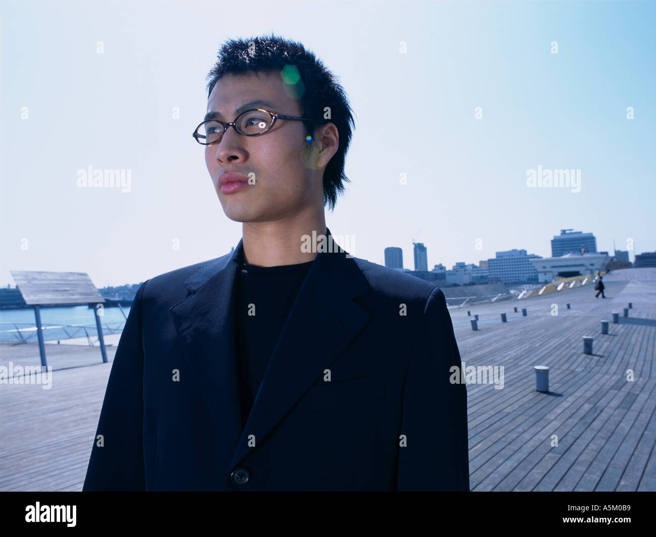 Asian man standing on a walkway Stock Photo