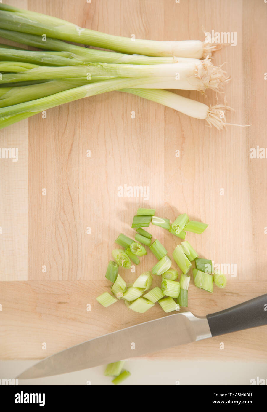 Chopped green onions on cutting board Stock Photo