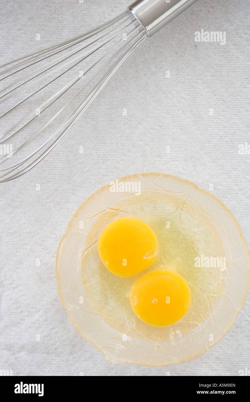 High angle view of whisk next to eggs in bowl Stock Photo