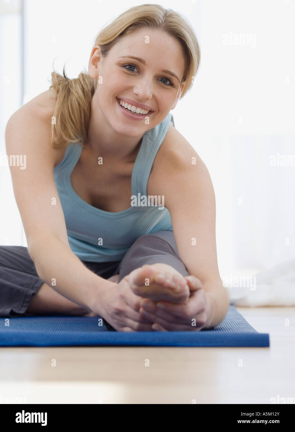 Woman stretching on yoga mat Stock Photo - Alamy