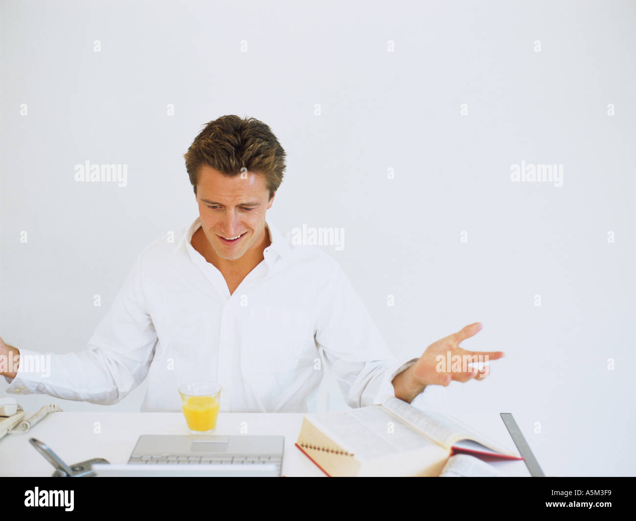 Caucasian sitting on a desk Stock Photo