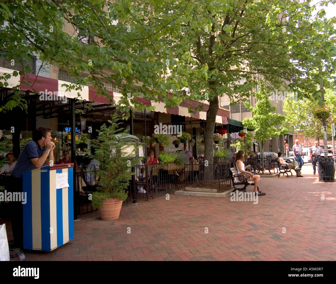 A view of a cobblestone street with outdoor restaurants in charming