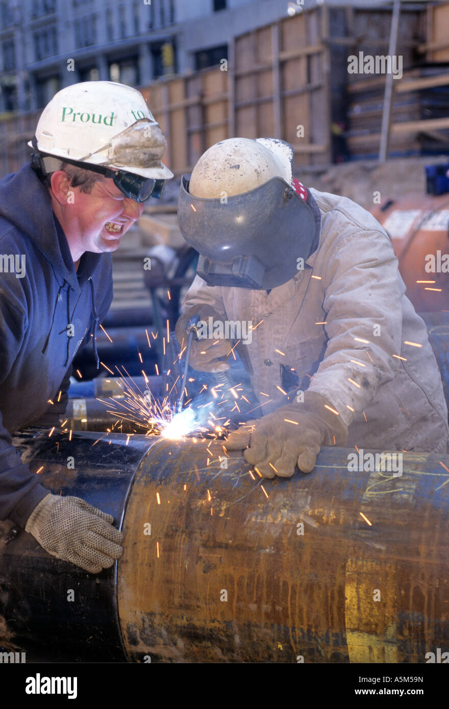 Welders attach drill bits to massive caissons for foundation of Random