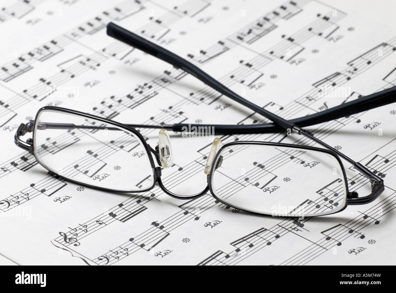 Spectacles on music manuscript Stock Photo