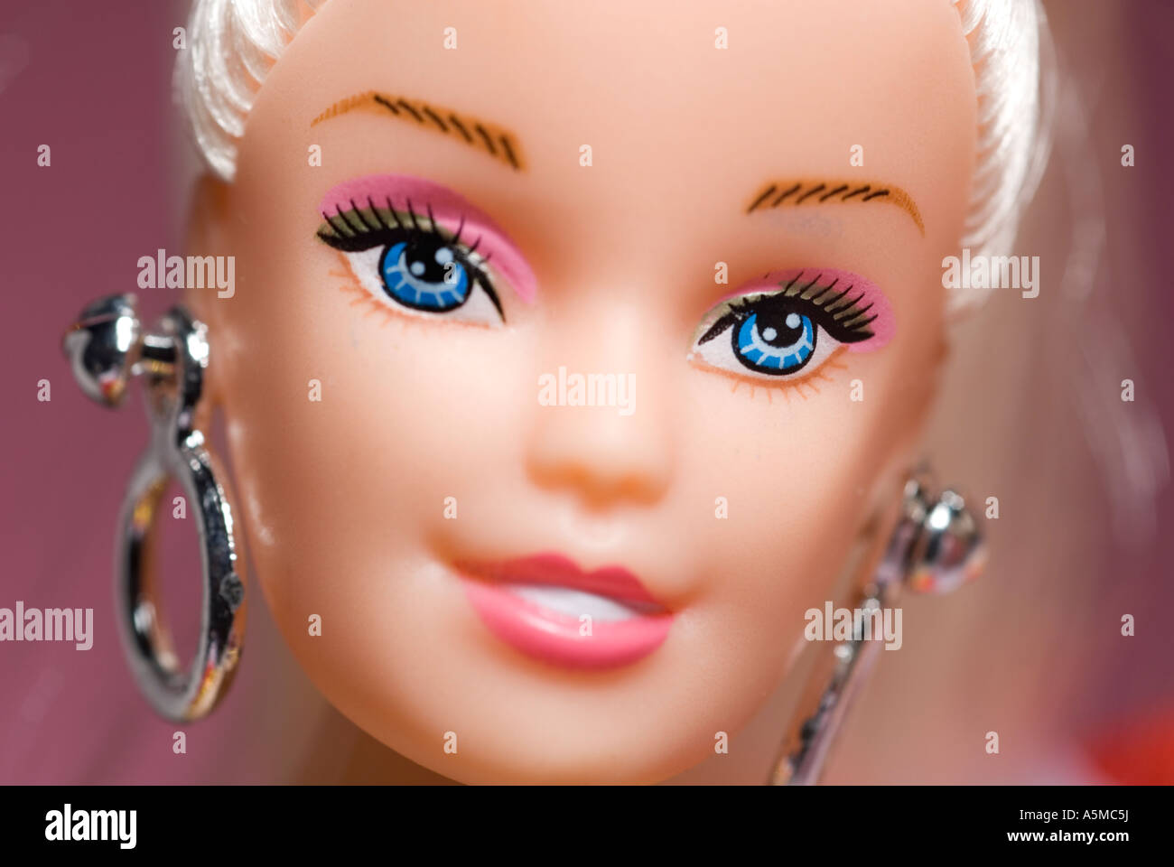 single doll face close up pink background Stock Photo