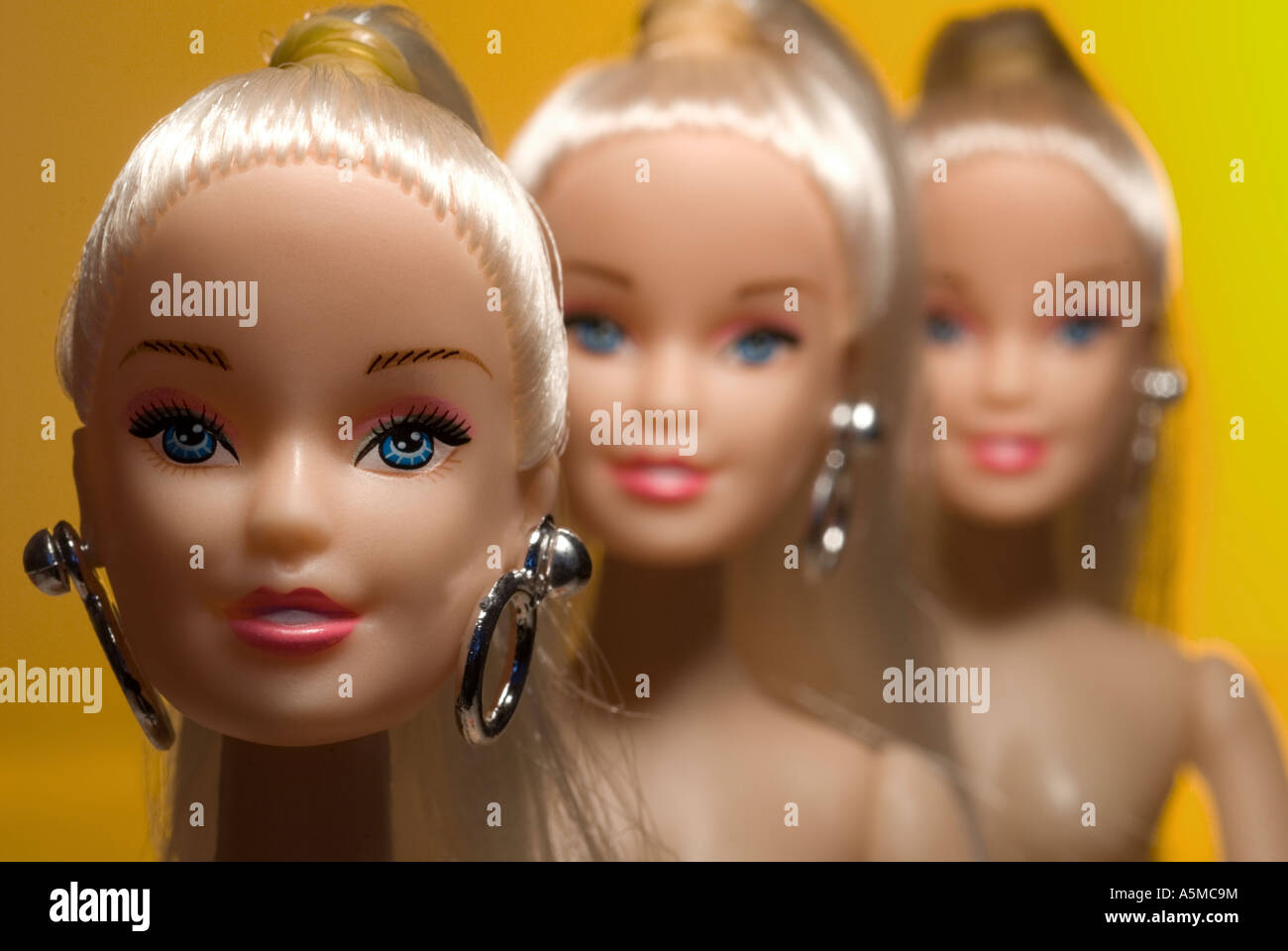 three dolls faces close up in a line decending focus Stock Photo