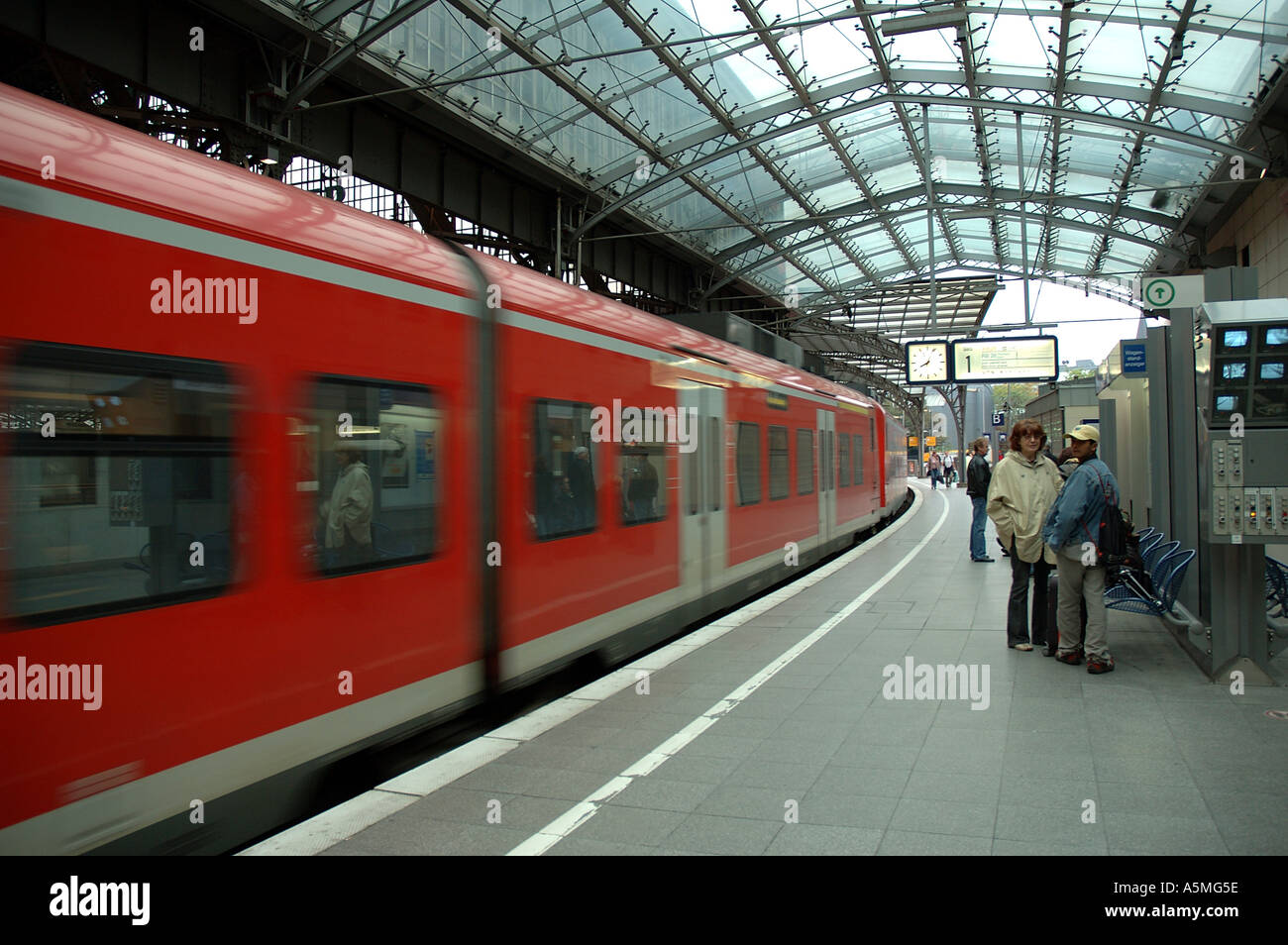 RAJ98758 Modern fast moving train transport red color at platform of Cologne Central Railway Station Germany Europe Stock Photo