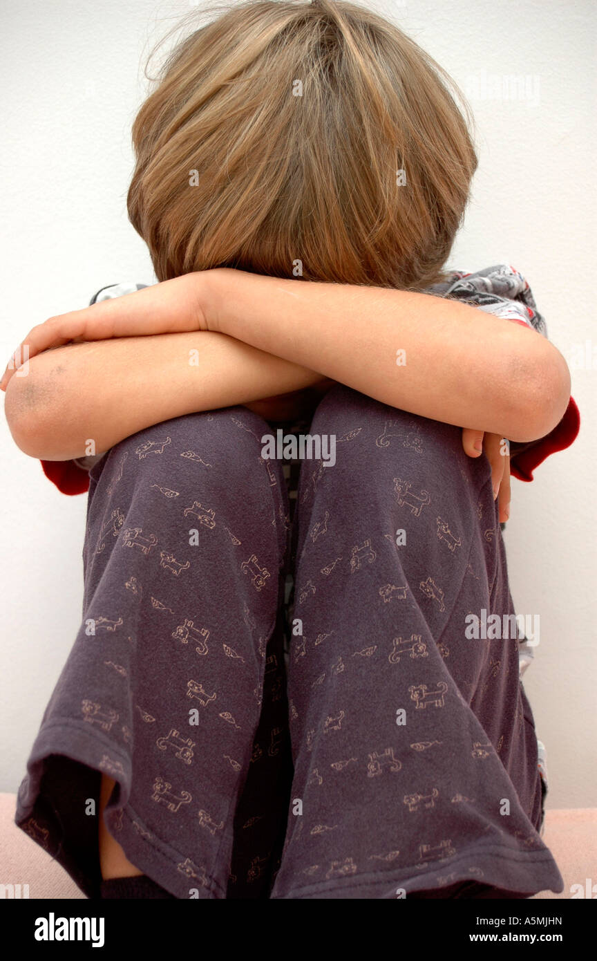 Symbolbild Kindesmissbrauch zusammengekeuaerter Junge symbolic for child molestation Kind Menschen Mensch Personen Leute people Stock Photo