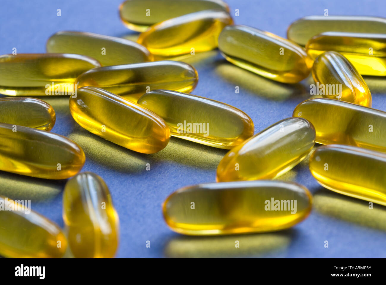 yellow gelcaps on a blue background Stock Photo