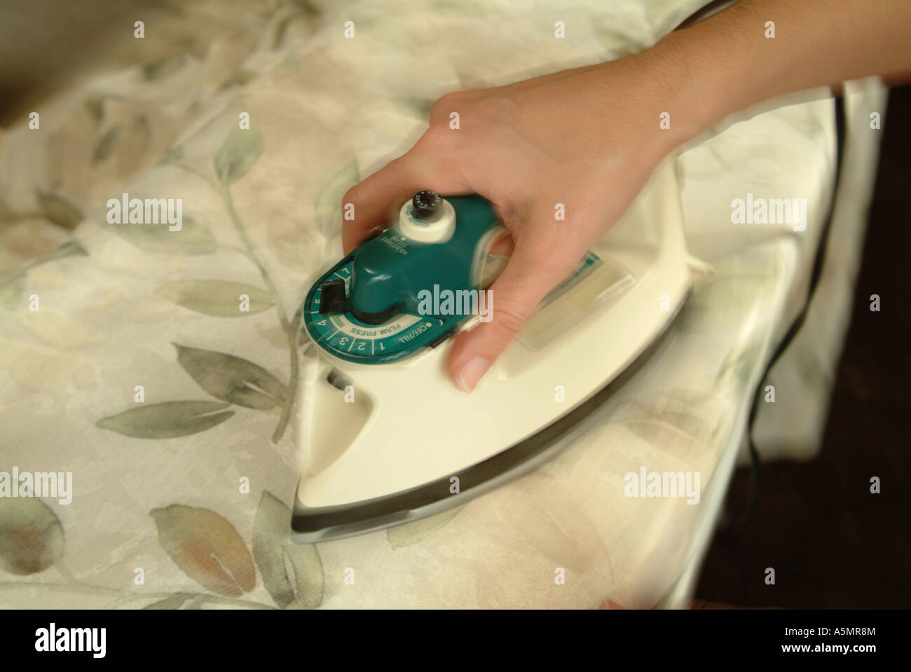 a tight crop of a womans hand ironing a tablecloth Stock Photo Alamy