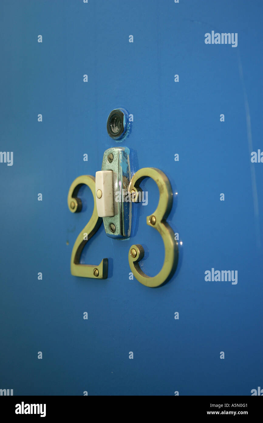 DOOR NUMBERS ON A BLUE DOOR WITH DOORBELL AND PEEPHOLE Stock Photo