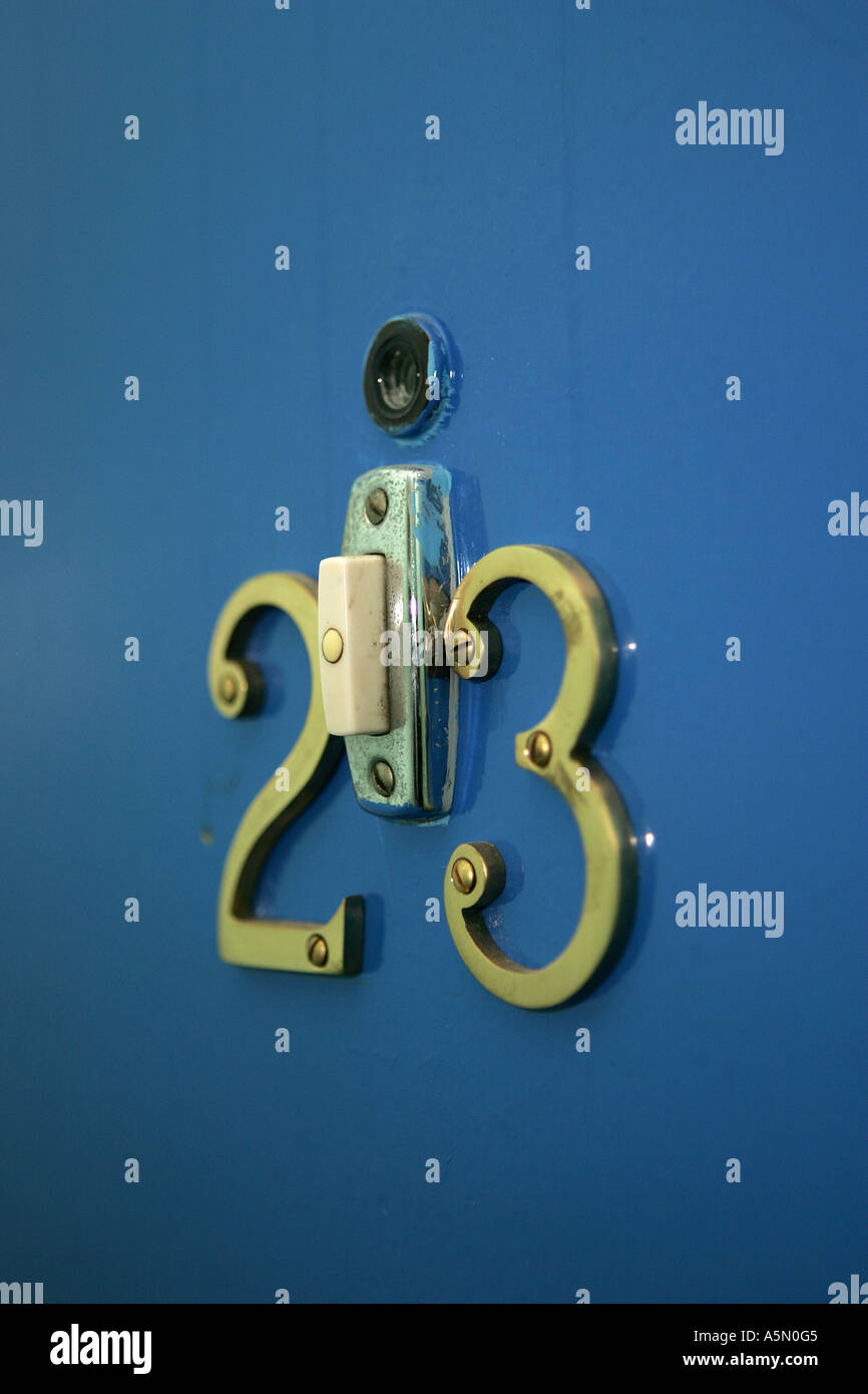DOOR NUMBERS ON A BLUE DOOR WITH DOORBELL AND PEEPHOLE Stock Photo