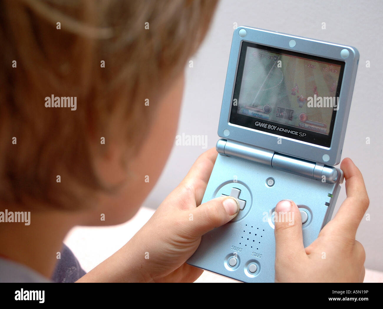 Junge spielt am Gameboy boy playing with Gameboy Kind Menschen Mensch Personen Leute people jung kindlich Kinder Kindheit child Stock Photo