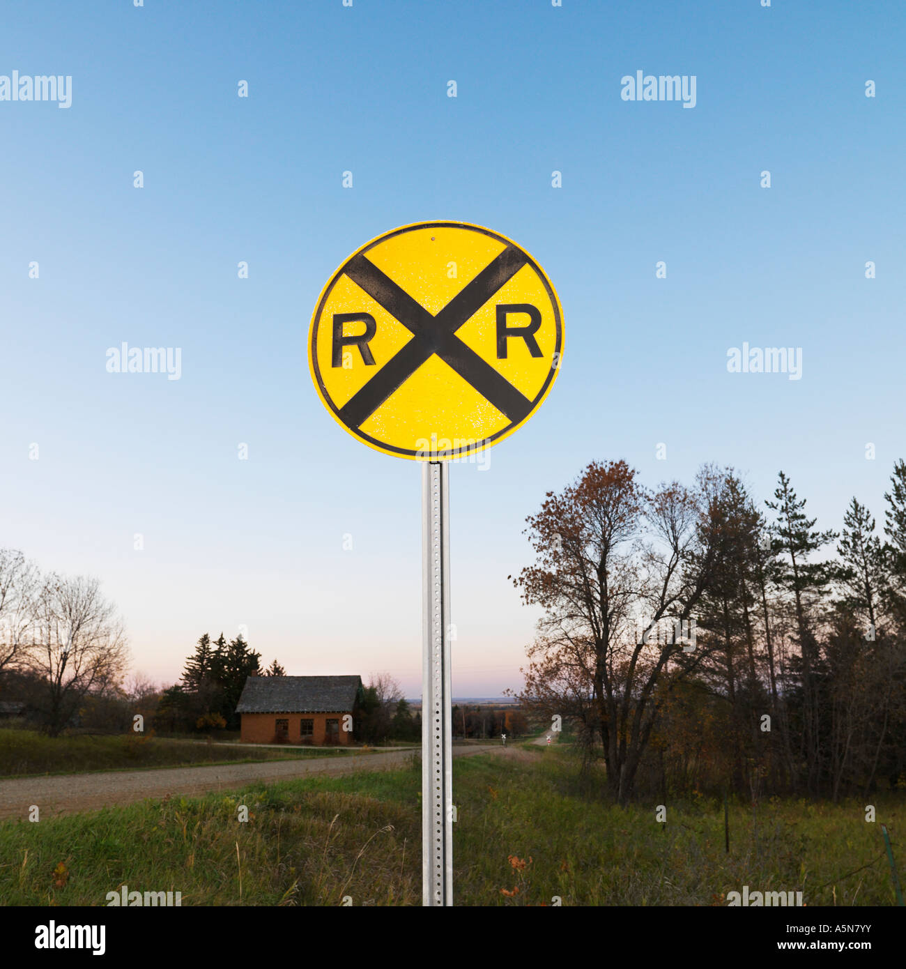 Circular yellow railroad grade crossing sign in rural setting Stock ...