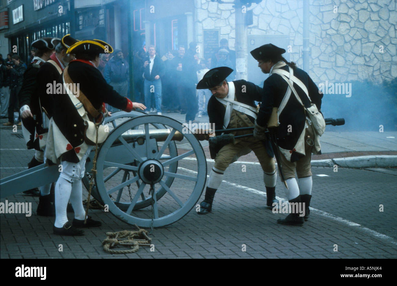 Costumed soldiers reload a small cannon on a brick paved street as part of the Reenactment of the Battle of Trenton New Jersey. Stock Photo