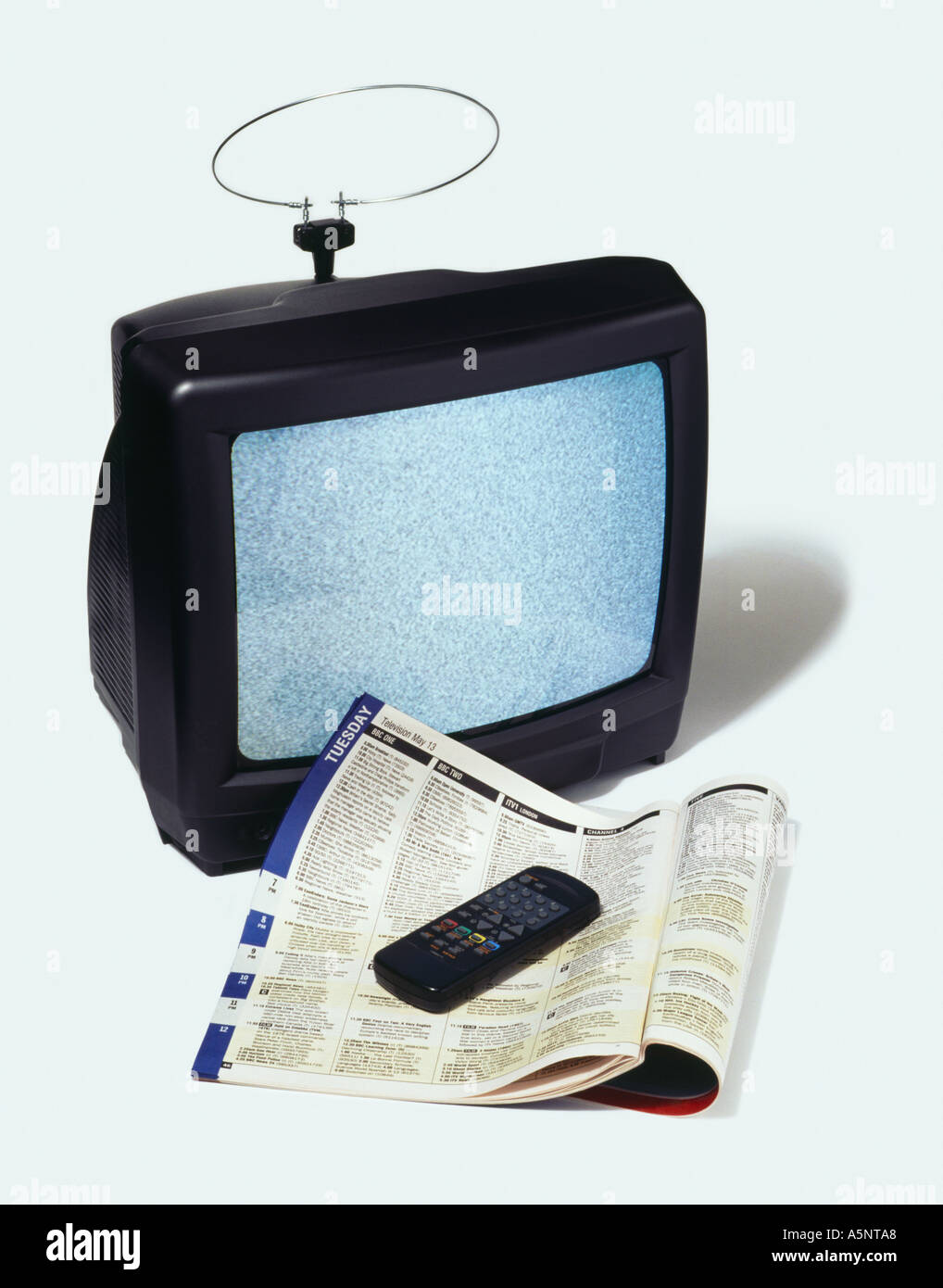 Television remote and TV guide Stock Photo