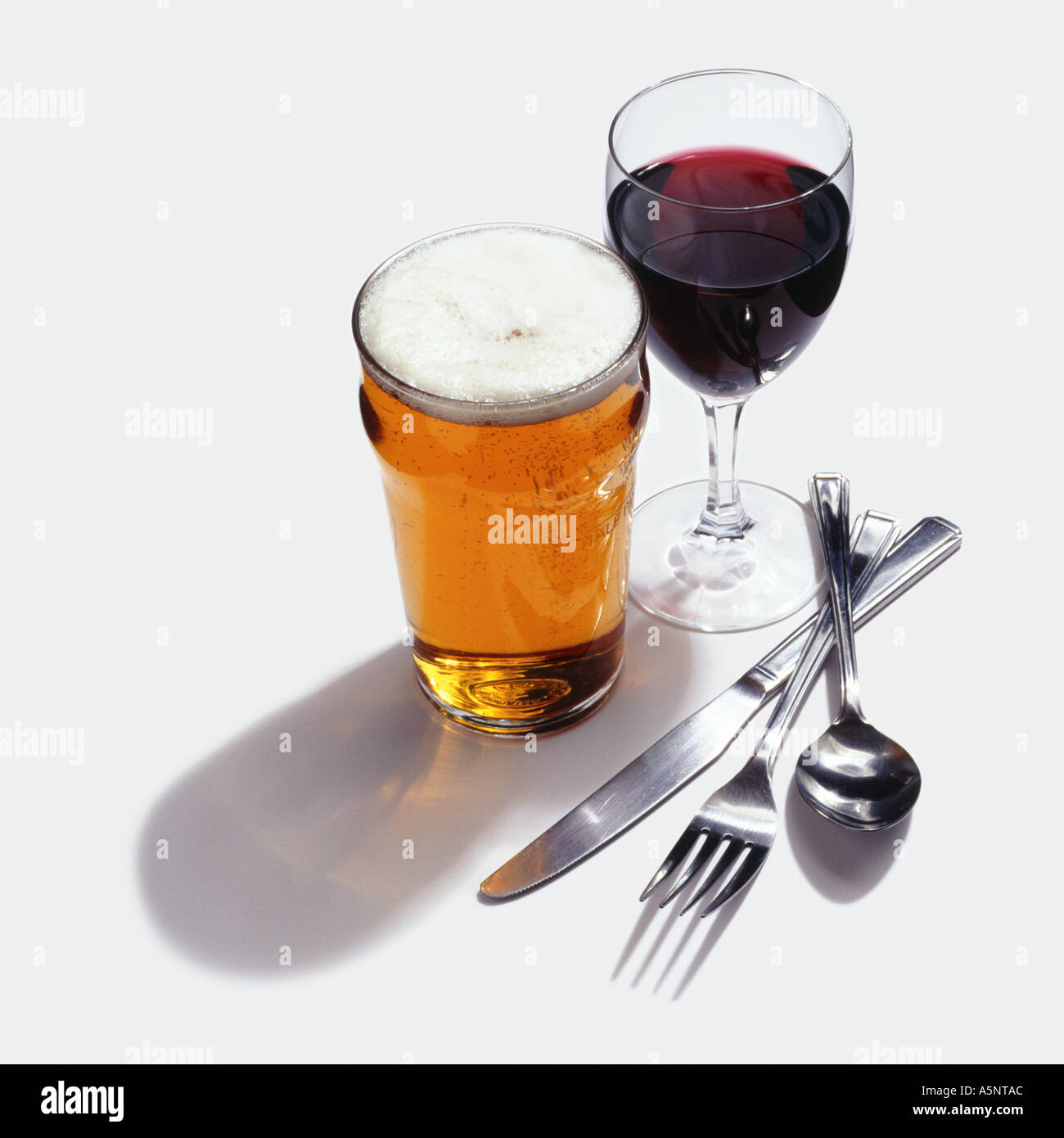 A glass of wine beer knife folk and spoon Stock Photo