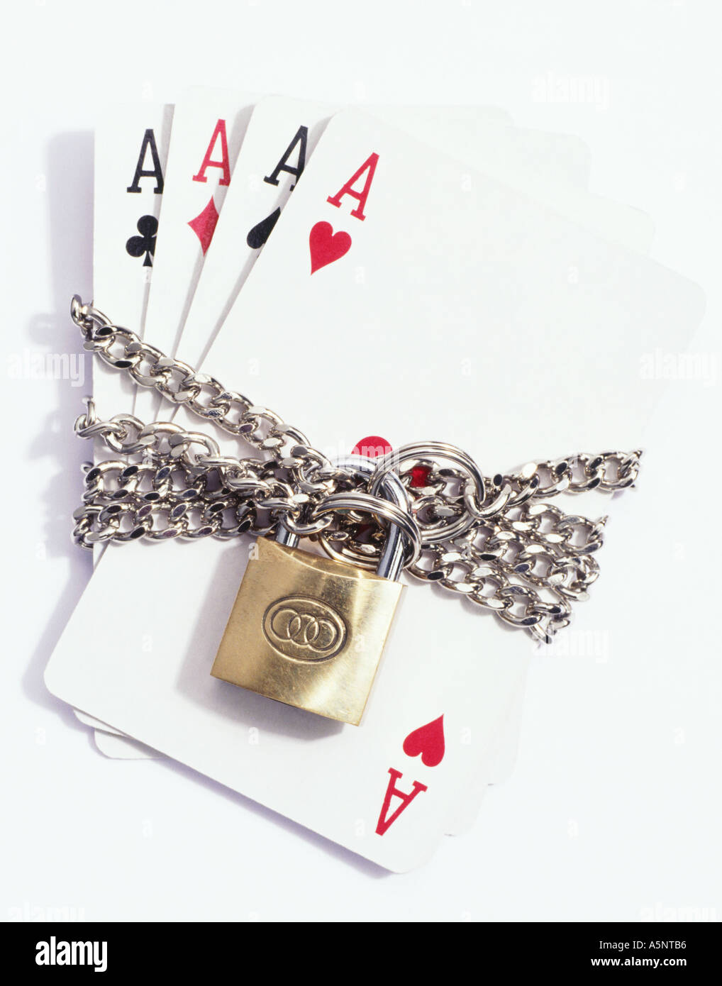 Four ace playing cards padlocked in chains Stock Photo