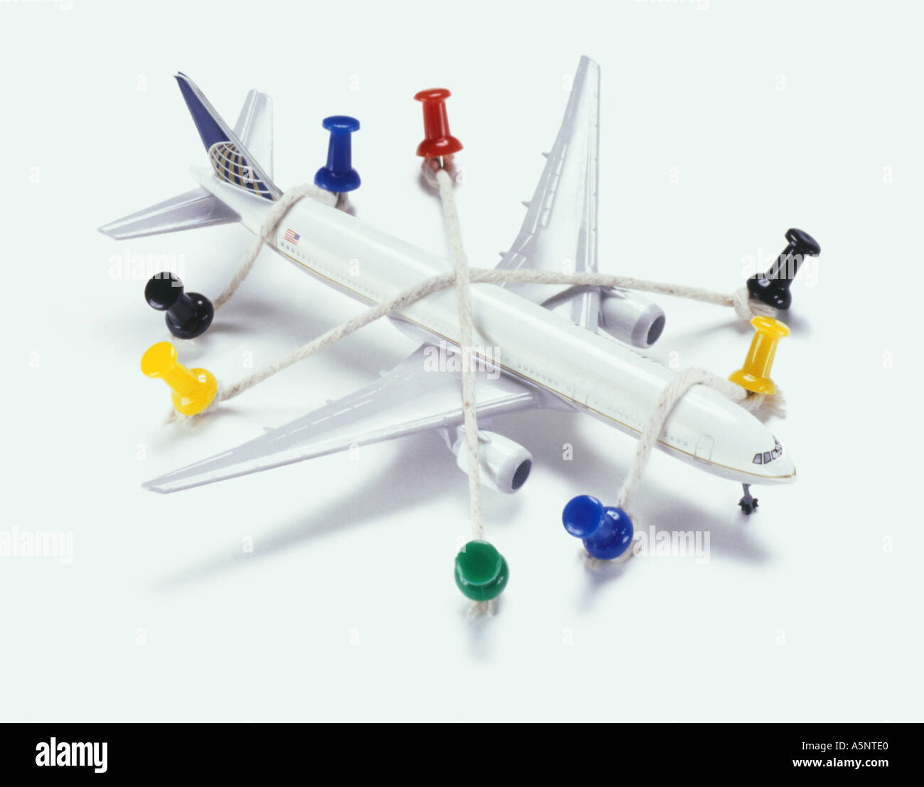 A model plane tied down with string and drawing pins Stock Photo