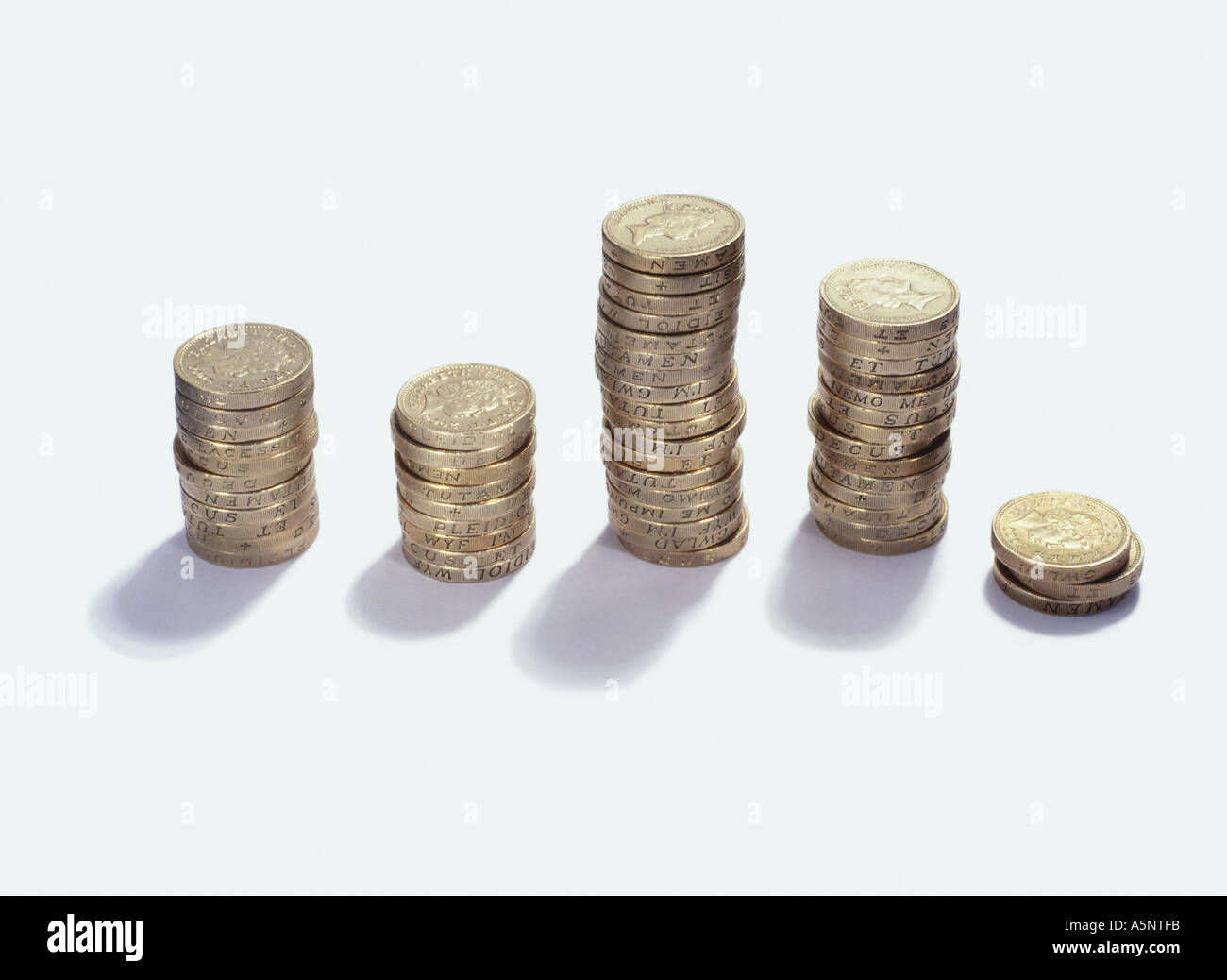 Five piles of one pound coins in a row Stock Photo