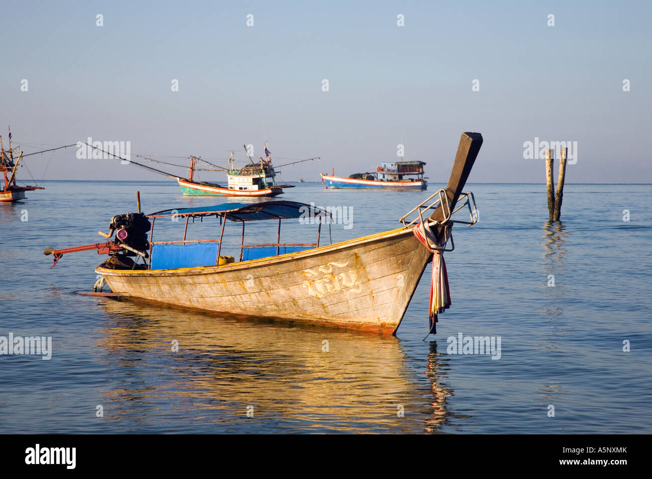 Longtailed fishermans Boat moored on still Andaman sea Krabi Beach Resort Krabi Province Southern Thailand Stock Photo