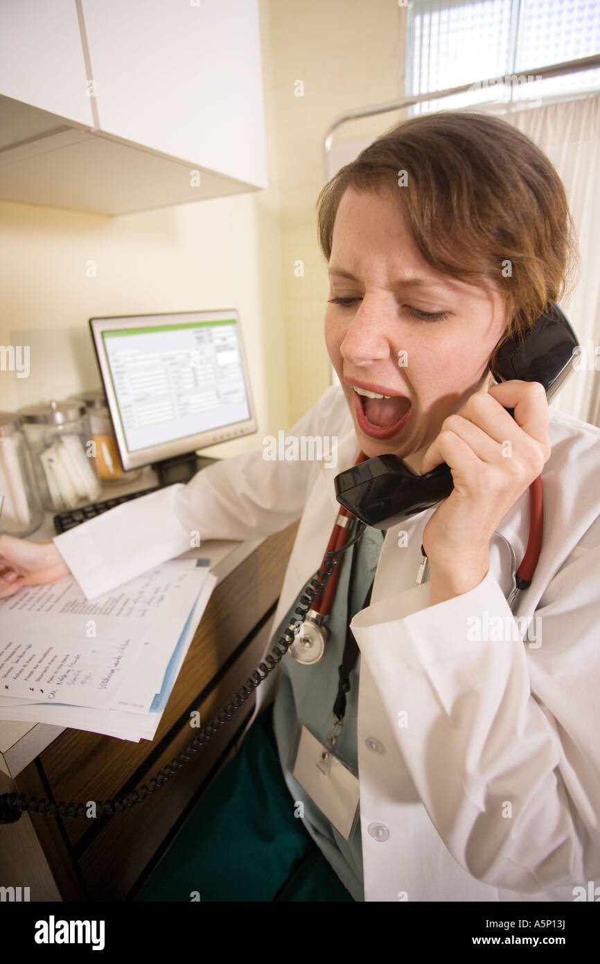 Female physician yelling with emotion on the telephone. Stock Photo