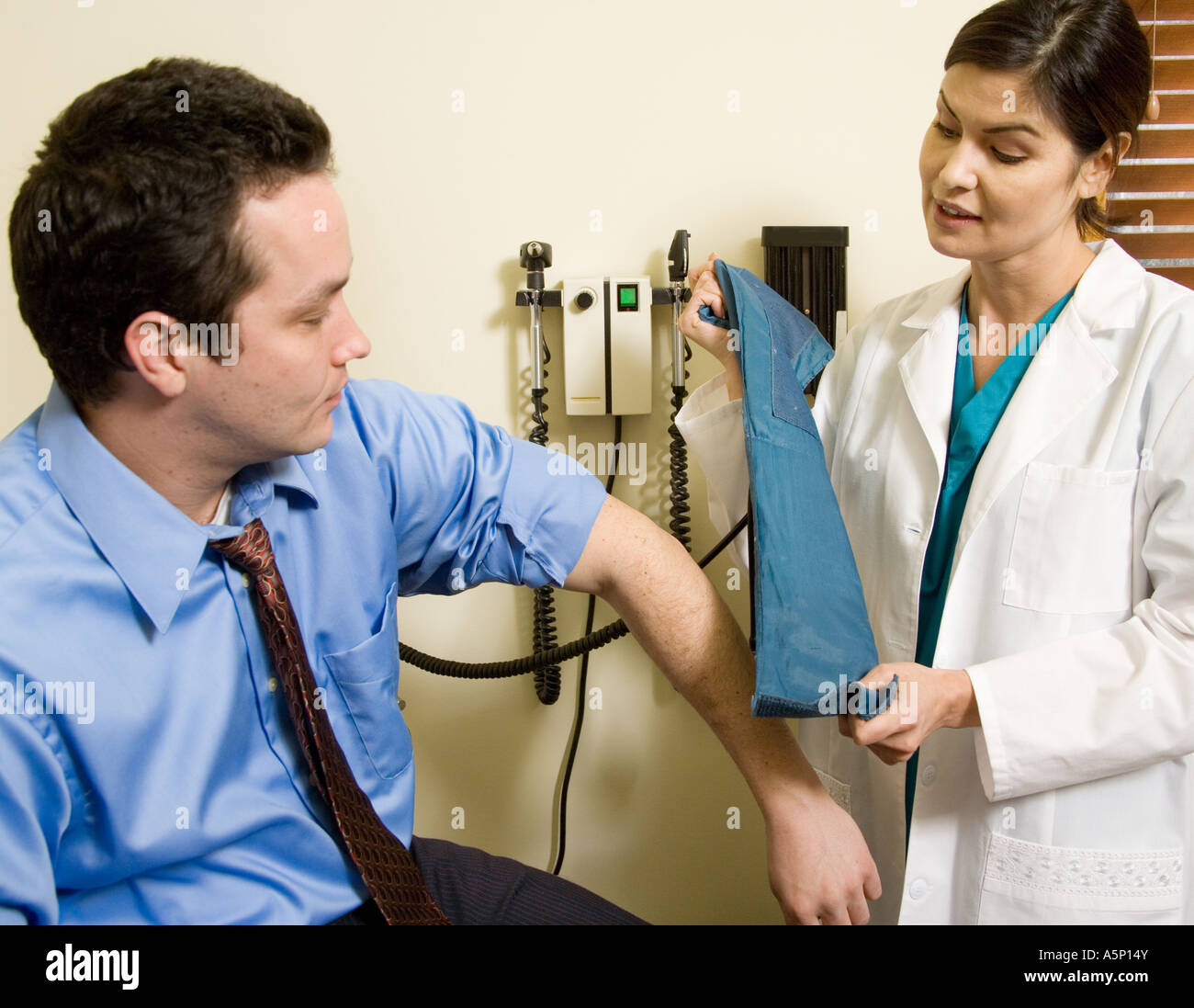 Male patient has his blood pressure measured during a physical exam