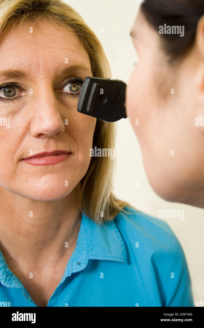 Doctor uses ophthalmoscope to view the retina of patient during