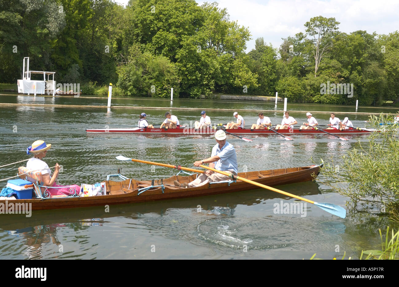 Skiff being rowed on the river  during the luncheon break as crews practice in background  at Henley Royal Regatta, Henley-on-Thames, England, UK Stock Photo