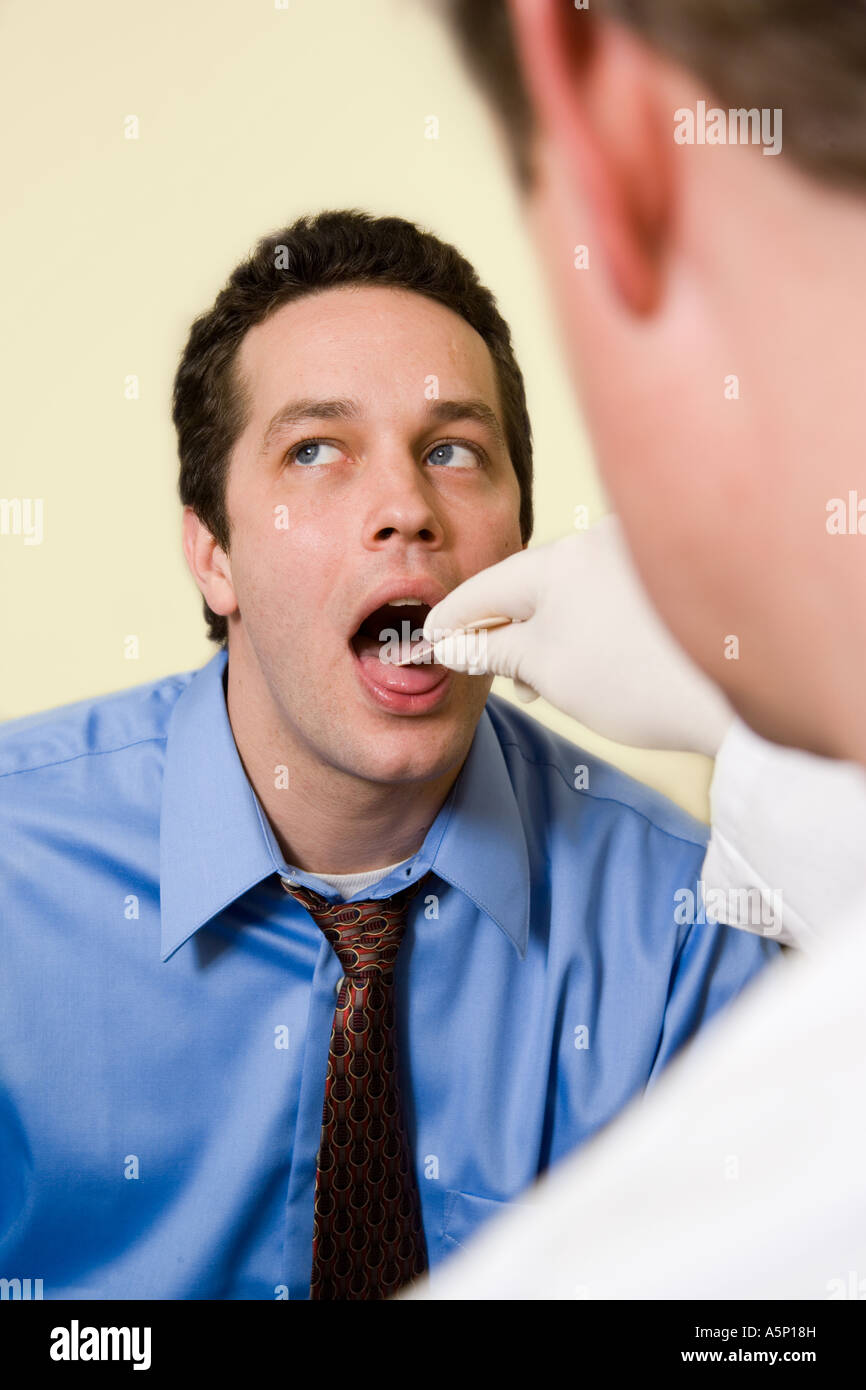 Physician takes a mouth swab from patient. Stock Photo