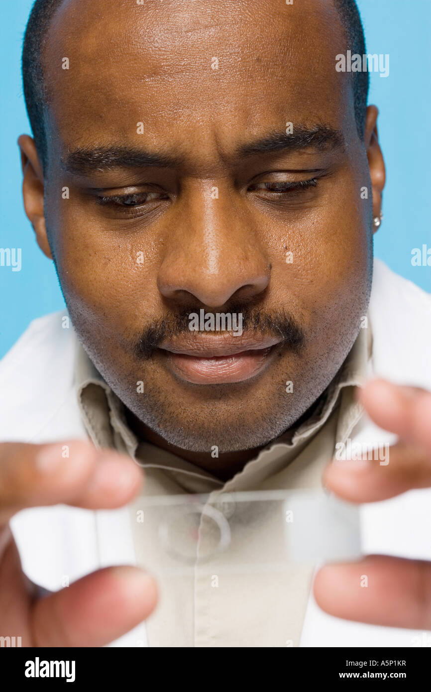 Biotechnology researcher examines a microtiter plate. Stock Photo