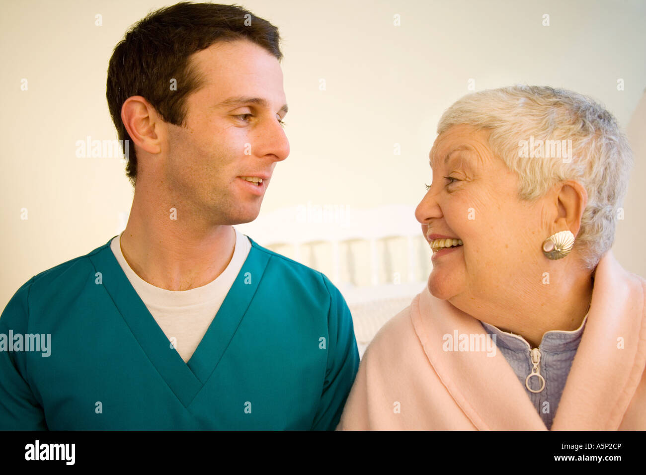 Orderly or nurse or doctor visits with female patient at home or in a nursing care facility. Stock Photo