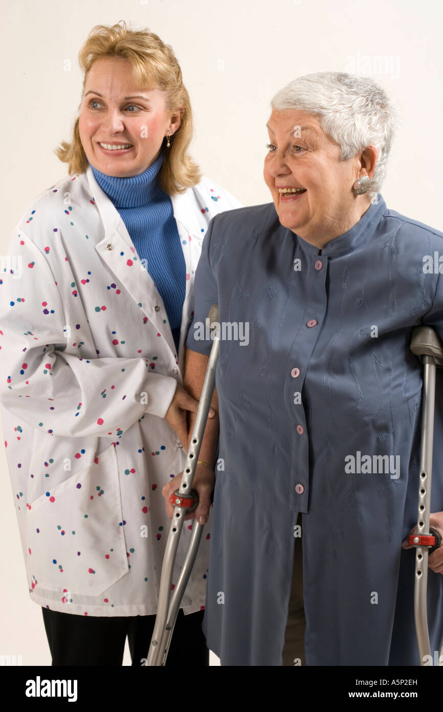 Home healthcare visiting nurse assists female patient with crutches