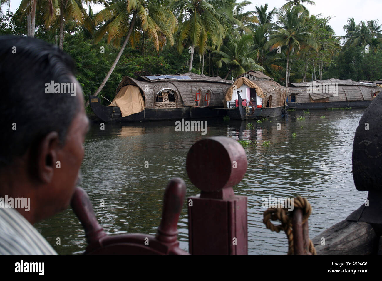 Portrait of a man steering a houseboat on the backwaters of Kerala Stock Photo